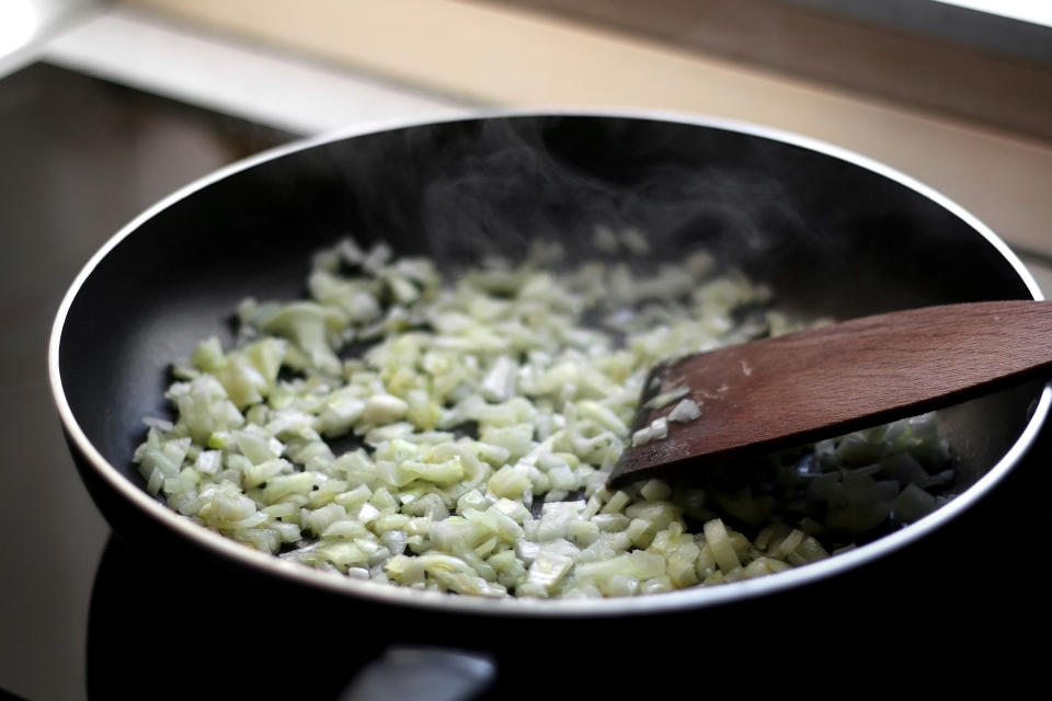 Frying onion on a pan with olive oil.