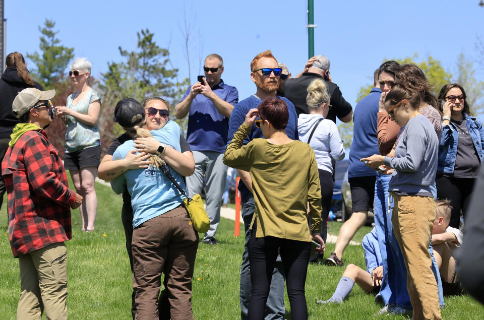 People gather at a site designated for parent and student reunifications following a report of a armed person outside Mount Horeb Middle School in Mount Horeb, Wis., Wednesday, May 1, 2024. (John Hart/Wisconsin State Journal via AP)