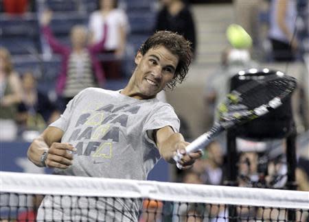 Rafael Nadal of Spain hits tennis balls into the crowd after defeating Rogerio Dutra Silva of Brazil at the U.S. Open tennis championships in New York, August 29, 2013. REUTERS/Shannon Stapleton