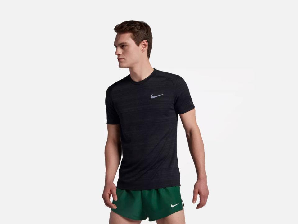 A model wearing the Nike Dri-Fit Miler shirt in black.