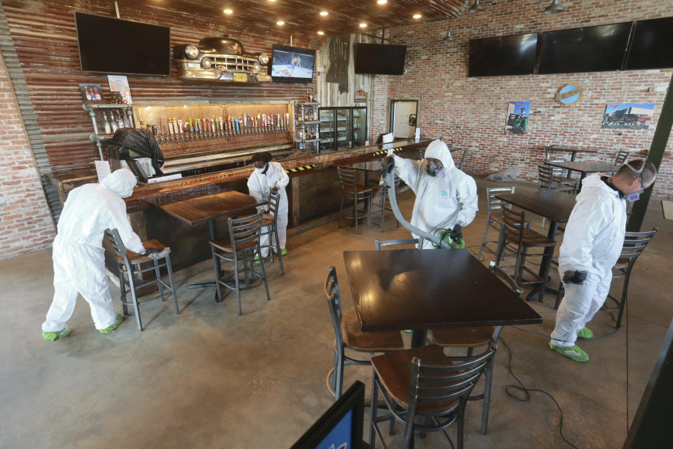 Workers from Servpro disinfect Mugshots restaurant in Tupelo, Mississippi, Friday, July 17, 2020, as the restaurant is preparing to open for business. (Thomas Wells/Northeast Mississippi Daily Journal via AP)