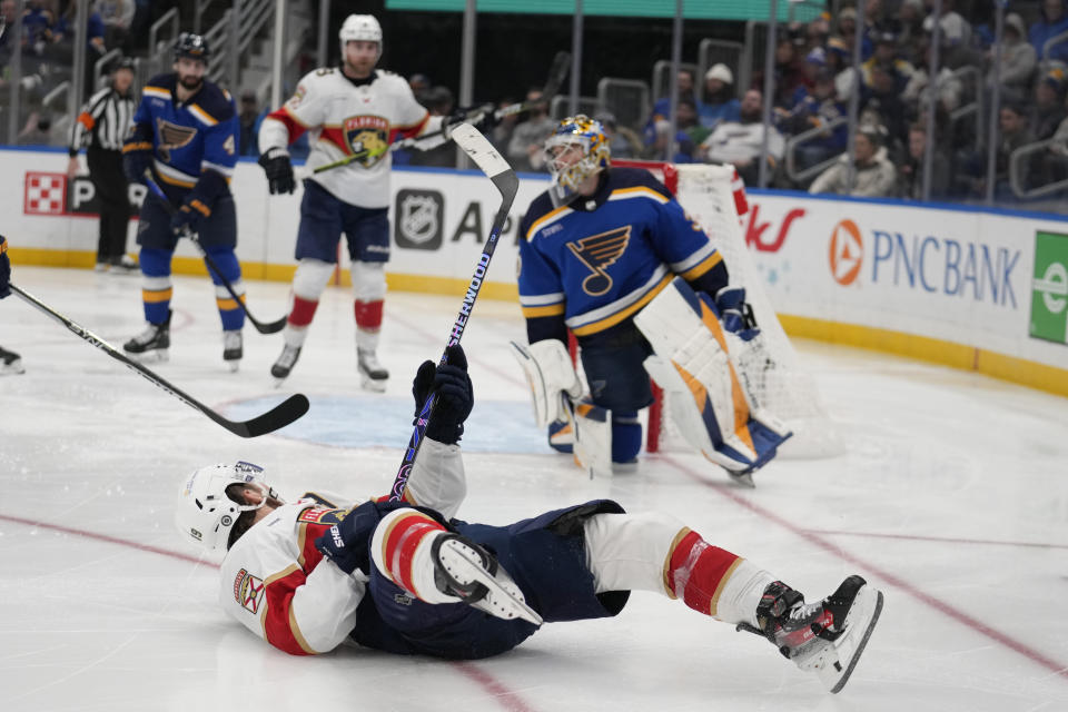 Florida Panthers' Matthew Tkachuk, bottom, falls after scoring past St. Louis Blues goaltender Joel Hofer during the third period of an NHL hockey game Tuesday, Jan. 9, 2024, in St. Louis. (AP Photo/Jeff Roberson)