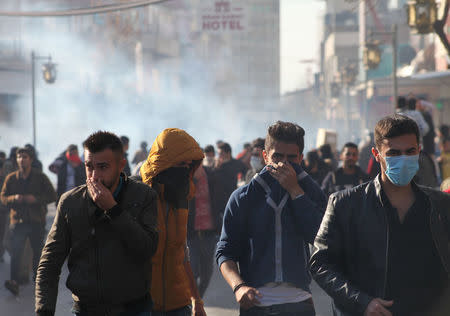 Kurdish protesters run away from tear gaz during a rally against the Kurdistan Regional Government (KRG) in Sulaimaniyah, Iraq December 18, 2017. REUTERS/Stringer. NO RESALES. NO ARCHIVES