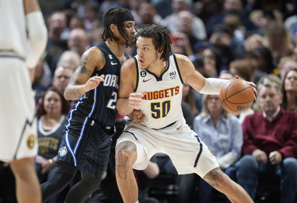 Denver Nuggets forward Aaron Gordon, right, works the ball inside against Orlando Magic guard Markelle Fultz in the first half of an NBA basketball game, Sunday, Jan. 15, 2023, in Denver. (AP Photo/David Zalubowski)