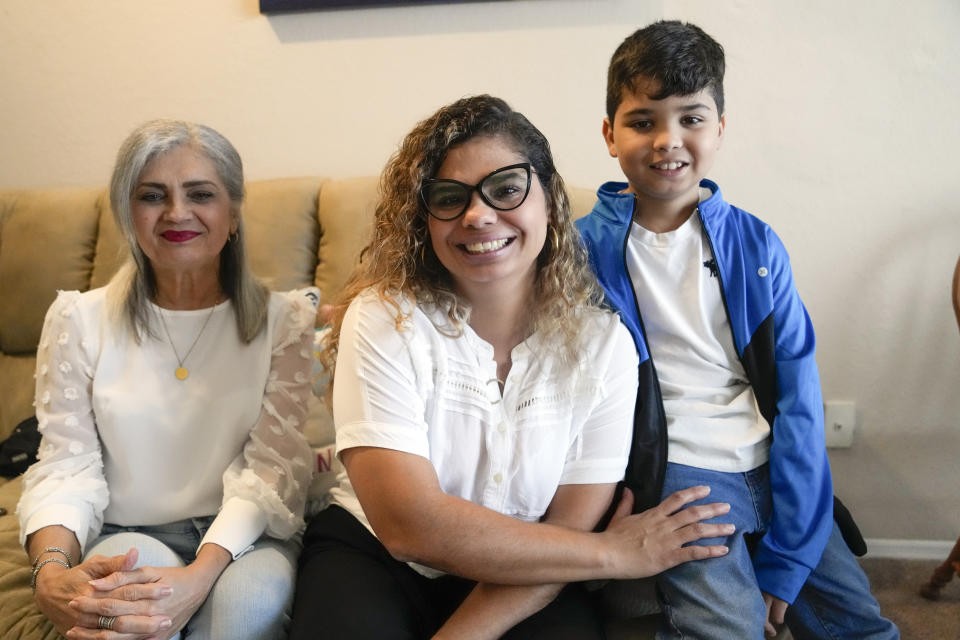 Caren Anez, center, with her 10-year-old son Lucas Tello, right, and her mother, Carmen Valbuena, pose for a picture at her apartment, Wednesday, Sept. 27, 2023, in Orlando, Fla. Anez and family, from Venezuela, are seeking TPS, Temporary Protected Status, that would allow them to have a temporary legal status, request work authorization and protection from deportation. (AP Photo/John Raoux)
