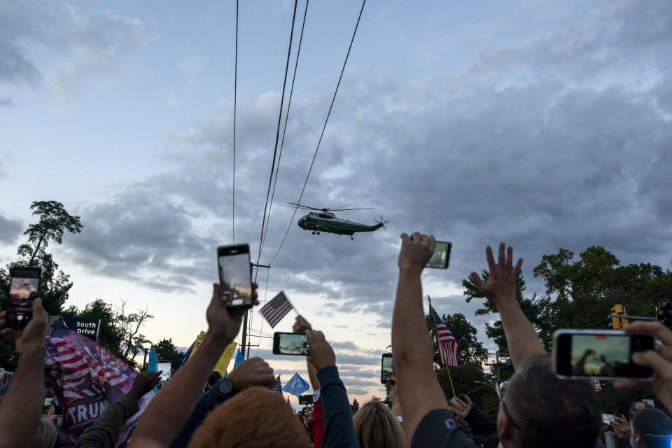 Marine One lifts off from Walter Reed National Military Medical Center in Bethesda, Md., as supporters cheer, Monday, Oct. 5, 2020. Stepping gingerly, President Donald Trump walked out the military hospital Monday night where he has been receiving an unprecedented level of care for COVID-19, immediately igniting a new controversy by declaring that despite his illness the nation should fear the virus that has killed more than 210,000 Americans. (AP Photo/Jose Luis Magana)