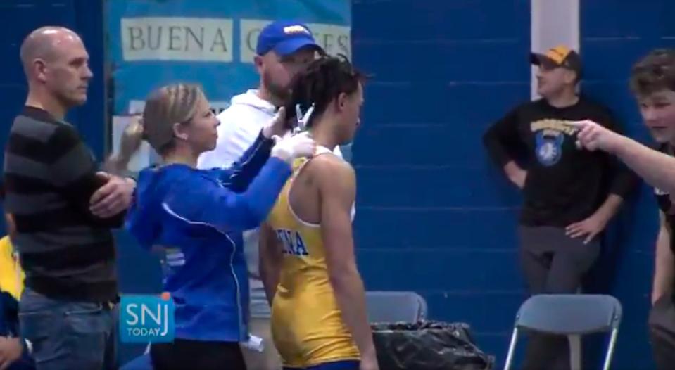 In this image taken from a video on Dec. 19, 2018, Buena Regional High School wrestler Andrew Johnson had his dreadlocks cut minutes before his match. Johnson, who is black, had a cover over his hair, but referee Alan Maloney, who is white, said that wouldn't be sufficient.