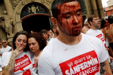 Animal rights protesters covered in fake blood react at the end of a demonstration for the abolition of bull runs and bullfights a day before the start of the famous running of the bulls San Fermin festival in Pamplona, northern Spain, July 5, 2016. REUTERS/Susana Vera