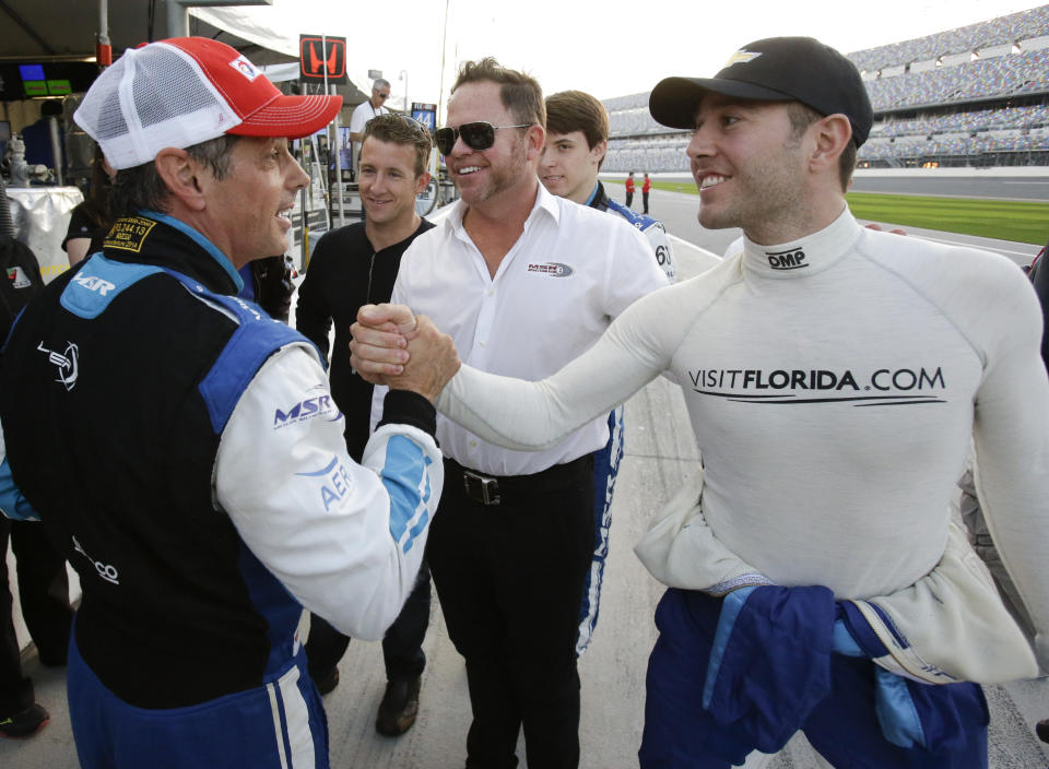 FILE - Oswaldo Negri, Jr., left, of Brazil, is congratulated by driver Michael Valiante, right, after winning the pole position for the IMSA 24-hour auto race as co-driver AJ Allmendinger, second from left, car owner Michael Shank, center, and co-driver Matt McMurry, second from right, celebrate on pit road at Daytona International Speedway in Daytona Beach, Fla., in this Thursday, Jan. 22, 2015, file photo. It took Michael Shank years to break into IndyCar even as the small-time team owner did everything the right way. The long winding road finally crossed the finish line for the biggest win in team history, an improbable Indianapolis 500 victory that gave Shank the validation he's sought for so long. (AP Photo/John Raoux, File)