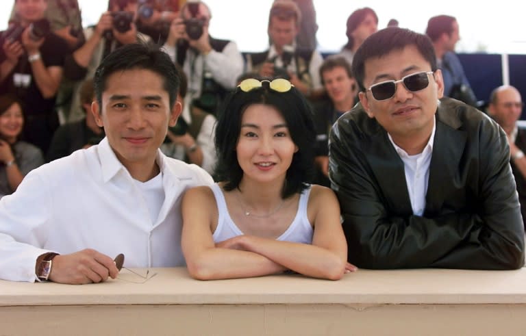 Chinese actors Maggie Cheung and Tony Leung (C) pose during the photocall of director Wong Kar-Wai's (R) movie 'In the Mood for Love', during the Cannes Film Festival, in 2000