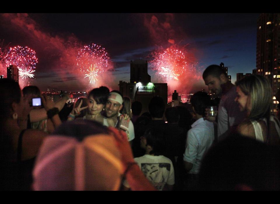 NEW YORK, NY - JULY 04:  Revelers celebrate at XVI lounge as fireworks explode over the Hudson River on July 4, 2011 in New York City. The United States celebrated its 235th anniversary of declaring independence from the British Empire. (Photo by Mario Tama/Getty Images)