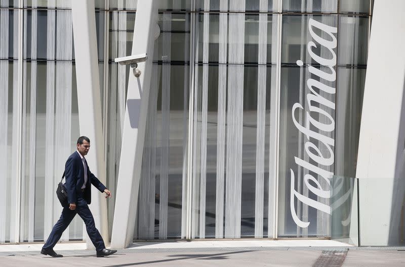 A man walks past a Telefonica building in Barcelona, July 31, 2014. Spain's Telefonica SA showed early signs of a turnaround in its biggest market Spain after reporting a 15 percent fall in second-quarter income. REUTERS/Albert Gea (SPAIN - Tags: BUSINESS TELECOMS) - RTR40SG0