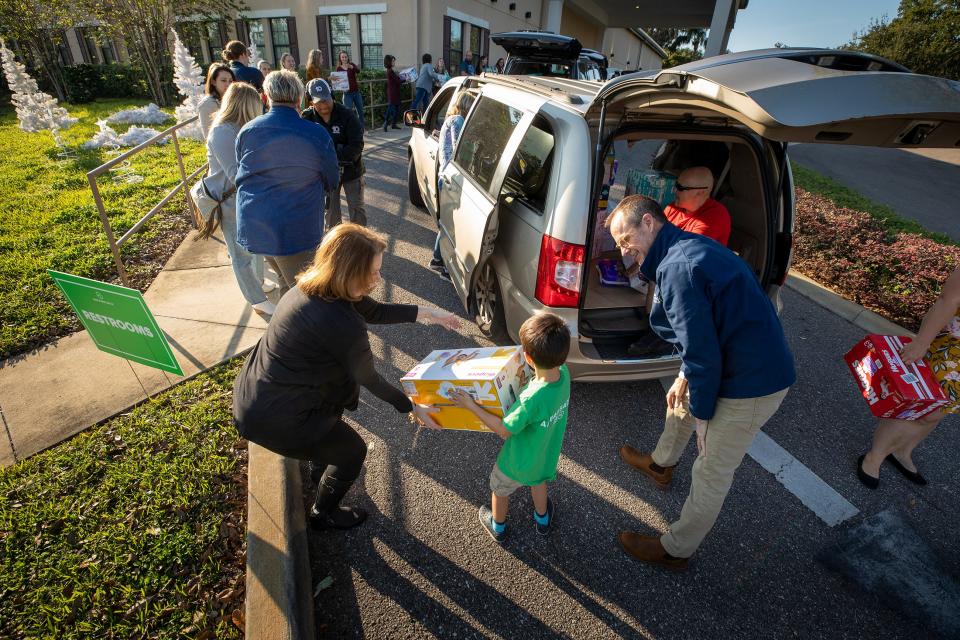 Jerry Haag, president and CEO of One More Child, unloads boxes of diapers Thursday afternoon as T.J. Moreno passes a box down a line of employees and volunteers. T.J., a 5-year-old from Lakeland, helped collect 162 boxes to be donated.