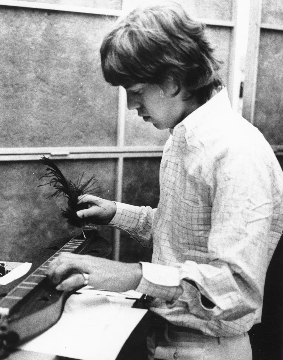 CIRCA 1965:  Singer Mick Jagger of the rock and roll band 'The Rolling Stones' plucks out some notes using a feather quill on a dulcimer in a recording studio in circa 1965. (Photo by Michael Ochs Archives/Getty Images)