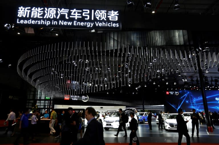 People visit the 'new-energy' vehicles area at the Shanghai Auto Show on April 19, 2017. With a quota threat looming, major manufacturers are announcing big plans to boost their electric vehicle (EV) offerings in China