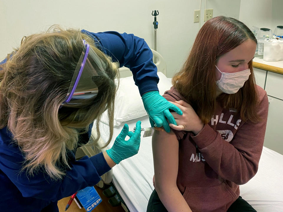 In this photo provided by Cincinnati Children’s Hospital Medical Center, clinical research coordinator Tammy Lewis-McCauley administers an injection to Katelyn Evans, a trial participant, as part of the hospital’s clinical trial of Pfizer's COVID-19 vaccine at Cincinnati Children’s Hospital Medical Center on Wednesday, Oct. 14, 2020. (Cincinnati Children’s Hospital Medical Center via AP)