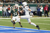 Penn State quarterback Beau Pribula, defended by Michigan State defensive back Khalil Majeed (34), runs for a 2-yard touchdown during the second half of an NCAA college football game, Friday, Nov. 24, 2023, in Detroit. (AP Photo/Carlos Osorio)