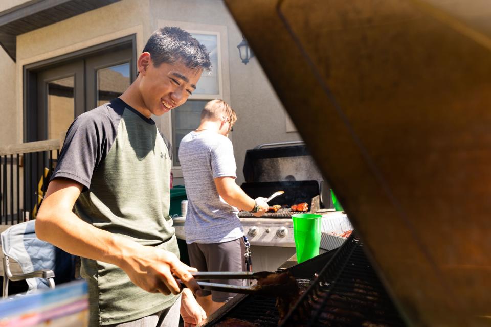 Jaron Wunder, 15, from Cedar Hills, cooks meat on the grill for a dinner plate sale where the proceeds will go to aiding Maui at organizer Jenny Wunder’s home in Cedar Hills on Saturday, Aug. 19, 2023. | Megan Nielsen, Deseret News