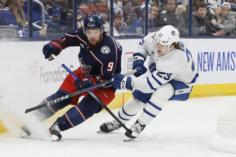 Columbus Blue Jackets' Ivan Provorov (9) and Toronto Maple Leafs' Matthew Knies (23) chase the puck during the third period of an NHL hockey game Saturday, Dec. 23, 2023, in Columbus, Ohio. (AP Photo/Jay LaPrete)