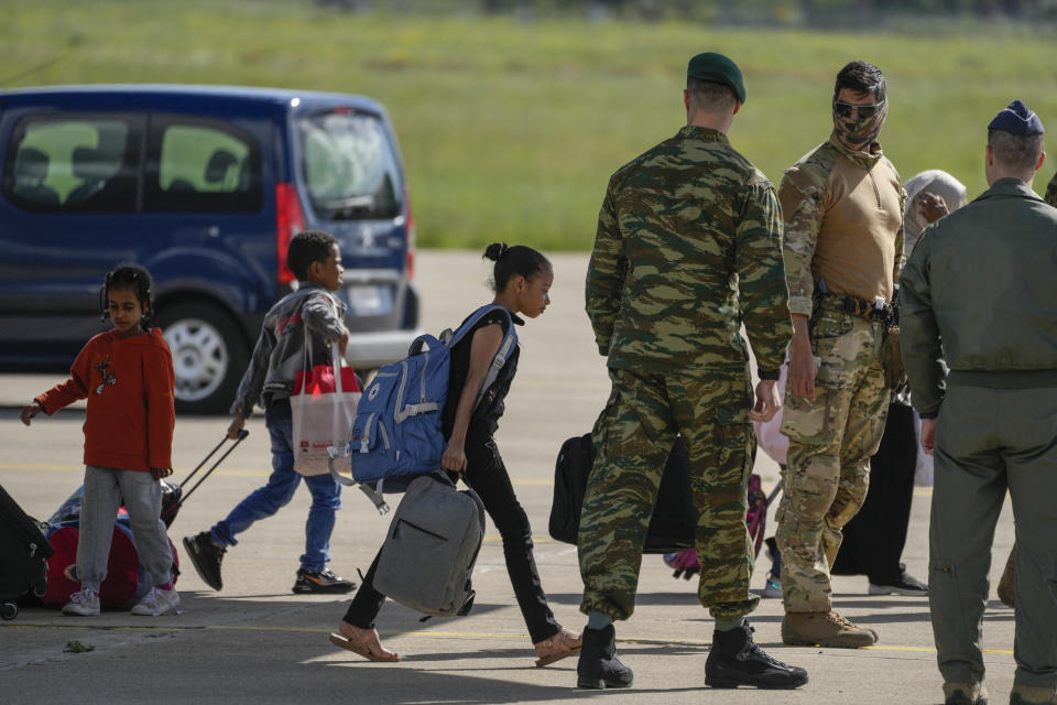 Passengers from Sudan disembark from a military plane at Tanagra air base, north of Athens, Wednesday, April 26, 2023. Sixteen Greeks and one Cypriot arrived in Greece after being evacuated from Sudan. (AP Photo/Thanassis Stavrakis)