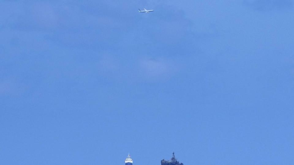 A U.S. Navy plane flies over BRP Sierra Madre, right, and Chinese coast guard ship at the Second Thomas Shoal, locally known as Ayungin Shoal, at the disputed South China Sea on Tuesday, Aug. 22, 2023. (Aaron Favila/AP)