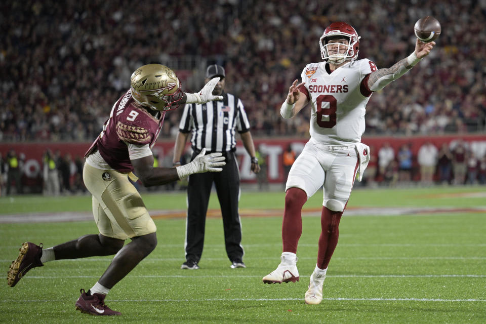 Oklahoma quarterback Dillon Gabriel (8) throws for a successful 2-point conversion past Florida State defensive end Derrick McLendon II (9) during the second half of the Cheez-It Bowl NCAA college football game, Thursday, Dec. 29, 2022, in Orlando, Fla. (AP Photo/Phelan M. Ebenhack)