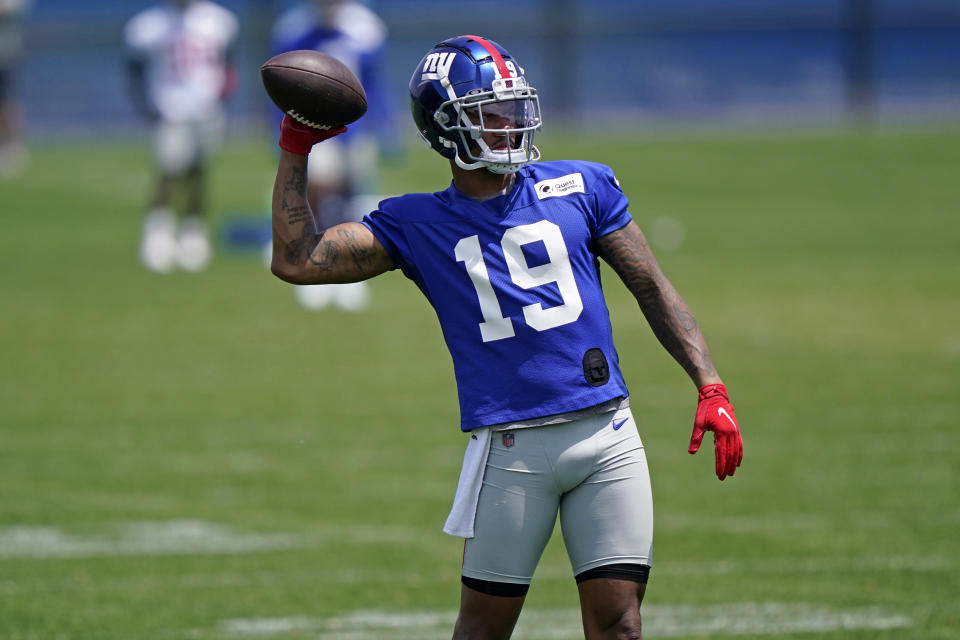 New York Giants wide receiver Kenny Golladay (19) passes the ball back to an assistant while running through light drills during an NFL football practice with the team, Thursday, June 10, 2021, in East Rutherford, N.J. (AP Photo/Kathy Willens)