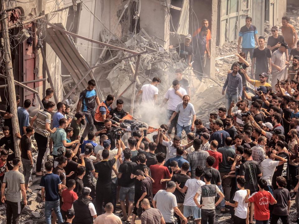 Palestinians evacuate a body following an Israeli airstrike on the Sousi mosque in Gaza City on October 9, 2023. I