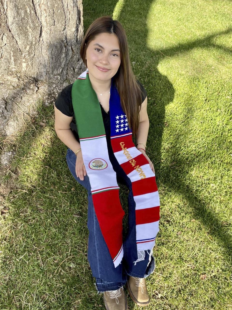 In this undated photo, Naomi Peña Villasano poses with a sash of both the Mexican and American flags that her school district barred her from wearing for her high school graduation ceremony. After Peña Villasano sued the district alleging that it violated her right to free speech, a federal judge in Colorado is weighing whether to let Peña Villasano wear the sash for graduation Saturday, May 27, 2023. (Daisy Jasmin Estrada Borja via AP)