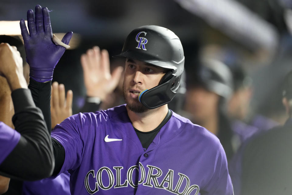 Colorado Rockies' C.J. Cron is congratulated as he returns to the dugut after hitting a three-run home run off Arizona Diamondbacks starting pitcher Madison Bumgarner during the sixth inning of a baseball game Saturday, Sept. 10, 2022, in Denver. (AP Photo/David Zalubowski)