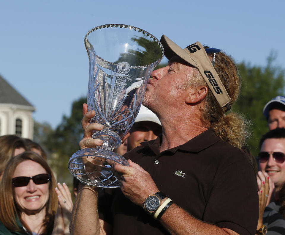 Miguel A. Jimenez kisses the trophy after wining the Greater Gwinnett Championship golf tournament of the Champions Tour, Sunday, April 20, 2014 in Duluth, Ga. (AP Photo/John Bazemore)