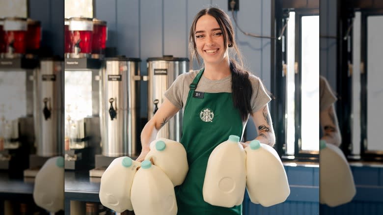 barista with milk jugs