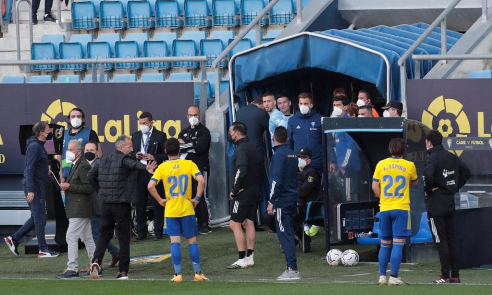 Cádiz players wait on the touchline after Valencia left the field on Sunday.