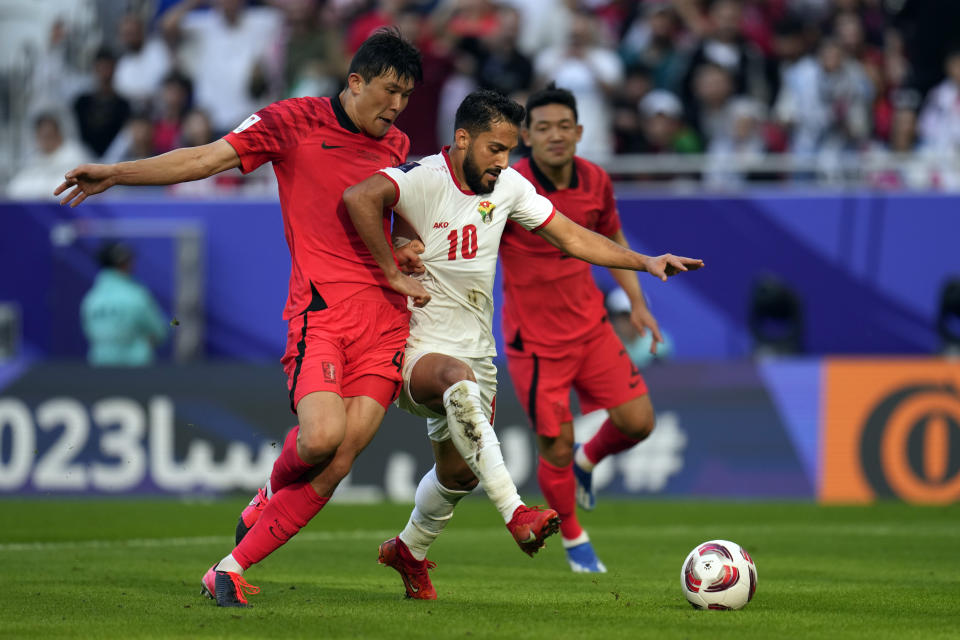 South Korea's Kim Min-jae, left, tries to stop Jordan's Mousa Altamari during the Asian Cup Group E soccer match between Jordan and South Korea at Al Thumama in Doha, Qatar, Saturday, Jan. 20, 2024. (AP Photo/Aijaz Rahi)