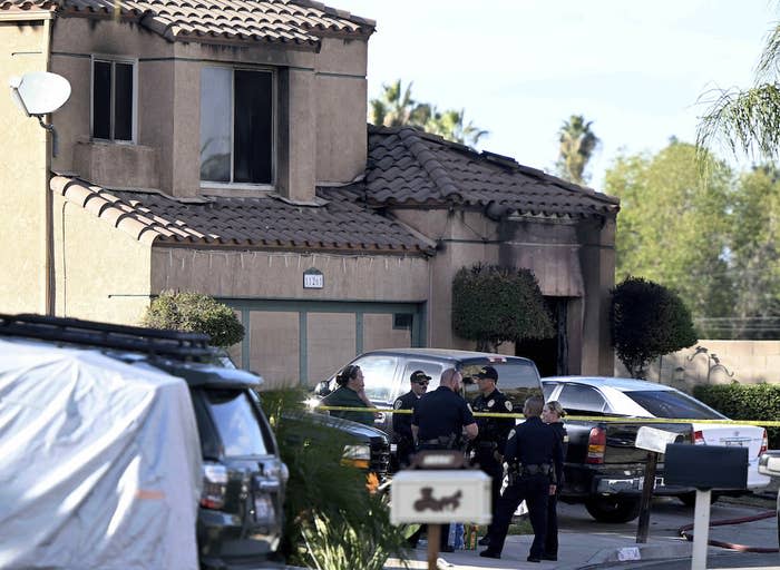 Firefighters and police gather outside a burned home in Riverside, California, on Nov. 25 following a house fire. Three bodies were found in the house that police are investigating as a homicide.