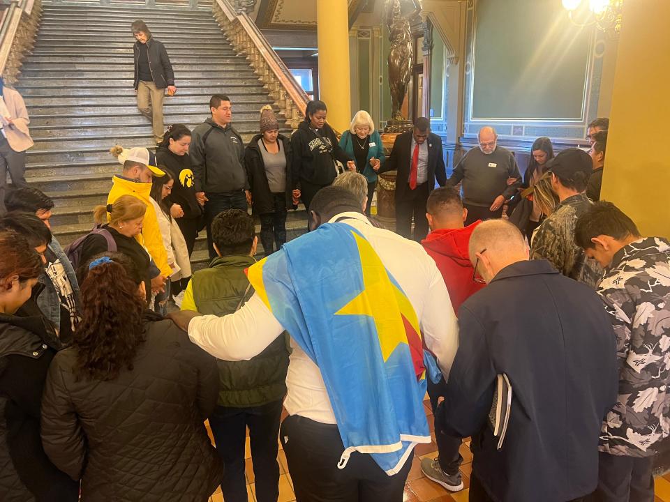 Migrant workers and advocates with Escucha Mi Voz Iowa, an Iowa City-based immigrant rights group, circle in prayer at the Iowa State Capitol on Feb. 12, 2024. The group traveled to the Capitol to speak against a slate of proposed bills they called "anti-immigration."