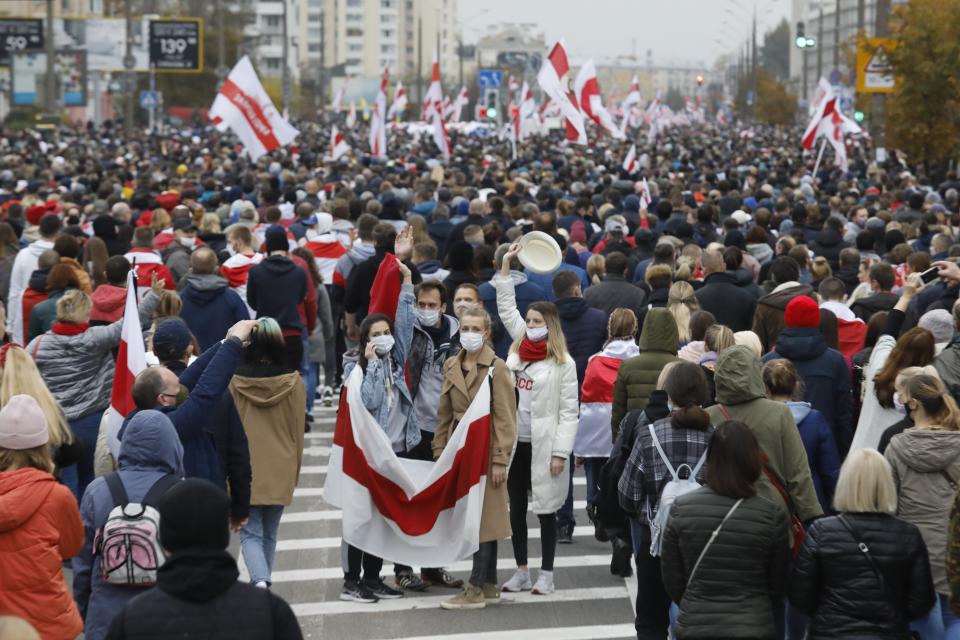 People with old Belarusian national flags march during an opposition rally to protest the official presidential election results in Minsk, Belarus, Sunday, Oct. 25, 2020. The demonstrations were triggered by official results giving President Alexander Lukashenko 80% of the vote in the Aug. 9 election that the opposition insists was rigged. Lukashenko, who has ruled Belarus with an iron fist since 1994, has accused the United States and its allies of fomenting unrest in the ex-Soviet country. (AP Photo)