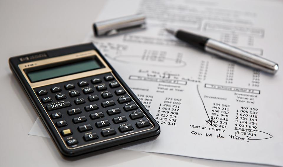 A closeup of a calculator and receipts