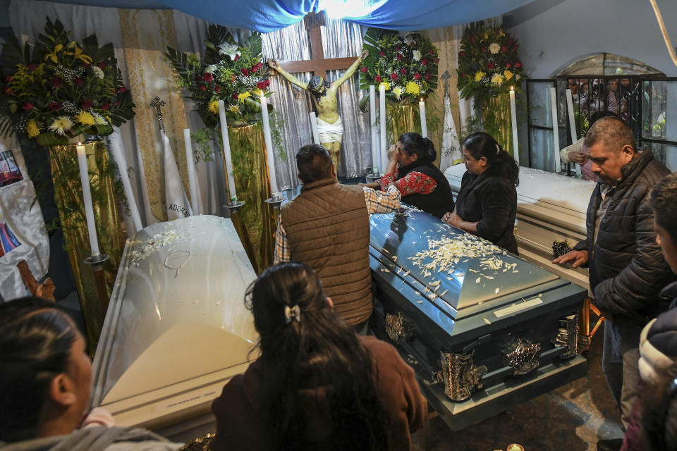 Familiares rodean los ataúdes con los restos de Jair Valencia, Misael Olivares y Yovani Valencia en la casa de su familia en San Marcos Atexquilapan, estado de Veracruz, México, el miércoles 13 de julio de 2022. (AP Foto/Félix Márquez)