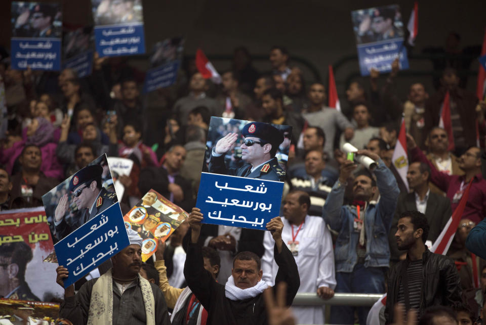 Egyptians attend a rally holding posters of Egypt's Defense Minister, Gen. Abdel-Fattah el-Sissi, with Arabic writing that reads"Port Said people love you," in support of el-Sissi, in Cairo, Egypt, Tuesday, Jan. 21, 2014. Supporters of the powerful army chief and defense minister urged Egyptians on Tuesday to turn the third anniversary to 2011 uprising that toppled longtime autocratic president Hosni Mubarak, to a show of gratitude to the general for ousting Islamist president, calling on him to contest elections. (AP Photo/Khalil Hamra)