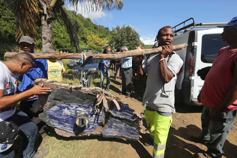 Local ecological association members and volunteers carry debris found on France’s Reunion Island in the Indian Ocean, during search operations for the missing MH370 flight (AFP/Getty Images)