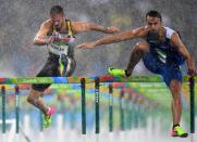 <p>Matthias Buhler of Germany and Milan Trajkovic of Cyprus compete in the rain during the Men’s 110m Hurdles Round 1 – Heat 2 on Day 10 of the Rio 2016 Olympic Games at the Olympic Stadium on August 15, 2016 in Rio de Janeiro, Brazil. (Getty) </p>