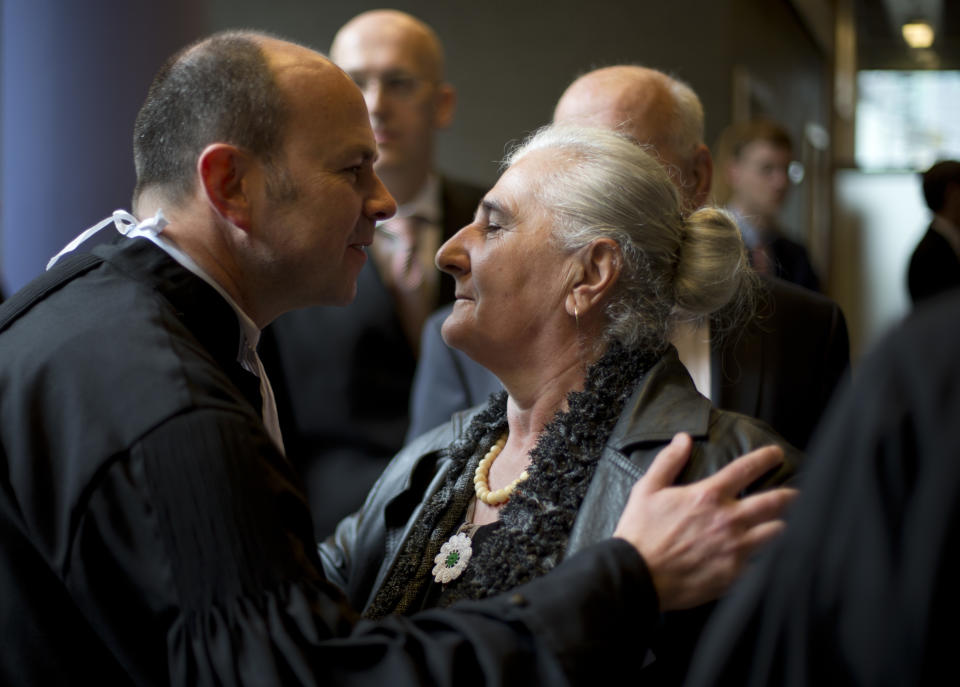 A women from the Bosnian town of Srebrenica hugs her lawyer Marco Gerritsen, left, prior to the start of a court case in The Hague, Netherlands, Monday, April 7, 2014. Mothers and widows of men murdered in Europe's worst massacre since World War II are suing the Dutch government for failing to protect their husbands and sons during the 1995 Srebrenica genocide. The civil case starting Monday in the courtroom focuses on the failure of Dutch troops serving as United Nations peacekeepers to protect Muslim men in the protected enclave in eastern Bosnia from rebel Serbs who overran the town and killed some 8,000 men and boys. (AP Photo/Peter Dejong)