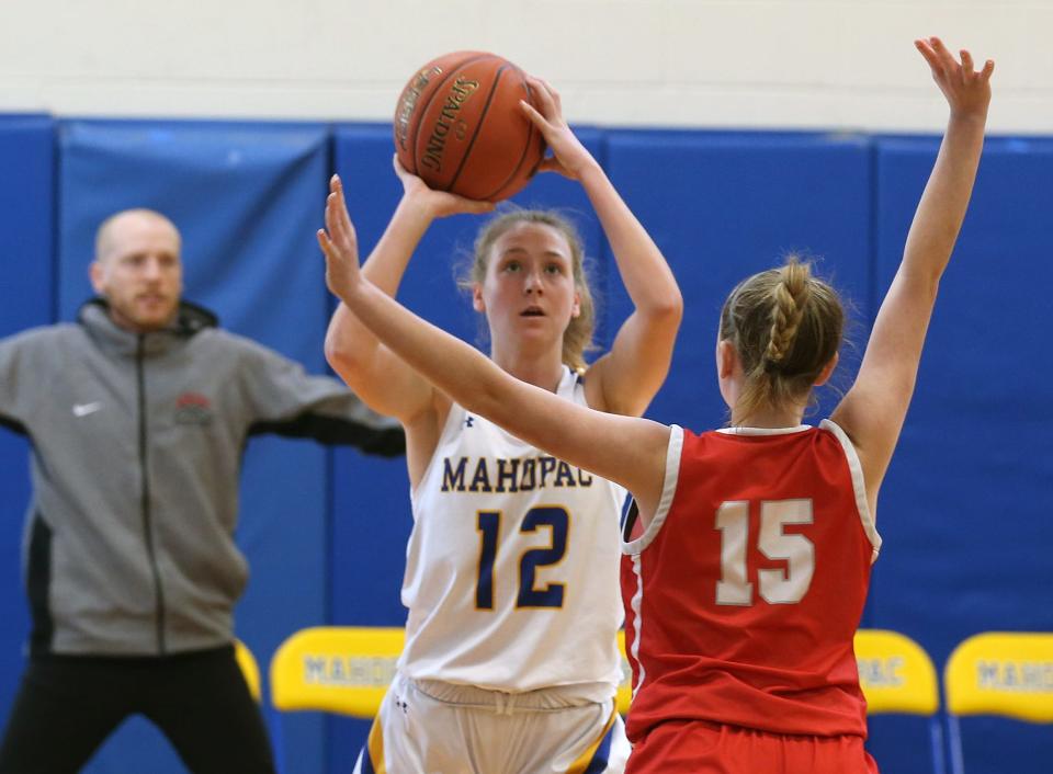 Mahopac's Piper Klammer (12) puts up a shot in front of  Somers Maddie Lyle (15) during girls basketball playoff action at Mahopac High School Feb. 18, 2023.  