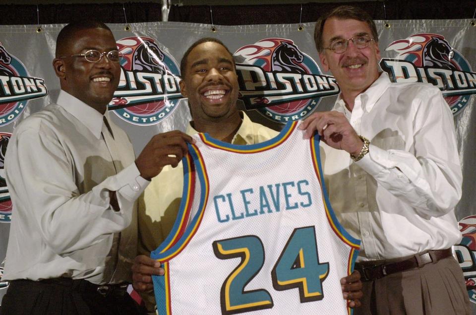 Mateen Cleaves, center, holds a Detroit Pistons jersey with his high school number with president of basketball operations Joe Dumars, left, and head coach George Irvine at the Palace of Auburn Hills, during a news conference.