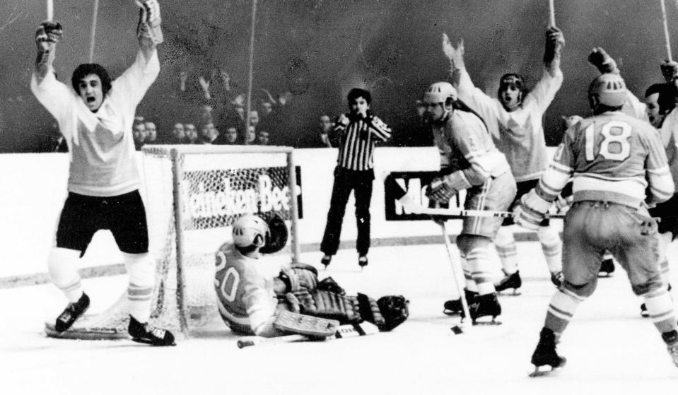 FILE - Team Canada's Phil Esposito, left, raises arms after scoring goal against Soviet goalie Vladislav Tretiak, on ice, in the final game of the Summit Series in Moscow, Sept. 28, 1972. Cheering with Esposito are Canada's Ron Ellis, right, and Paul Henderson, third from right. Other Soviets are Vladimir Lutchenko (3) and Vladimir Vikulov (18). Henderson, a former NHLer who will always be remembered for scoring the decisive goal in clinching Canada its Summit Series win over Russia some 50 years ago, will get more recognition on Saturday, when he'll celebrate his 80th birthday with a ceremonial puck drop before Cansius' game against Niagara. Henderson's grandson, Alton McDermott, is a left wing for Canisius. (AP Photo/TASS, File)