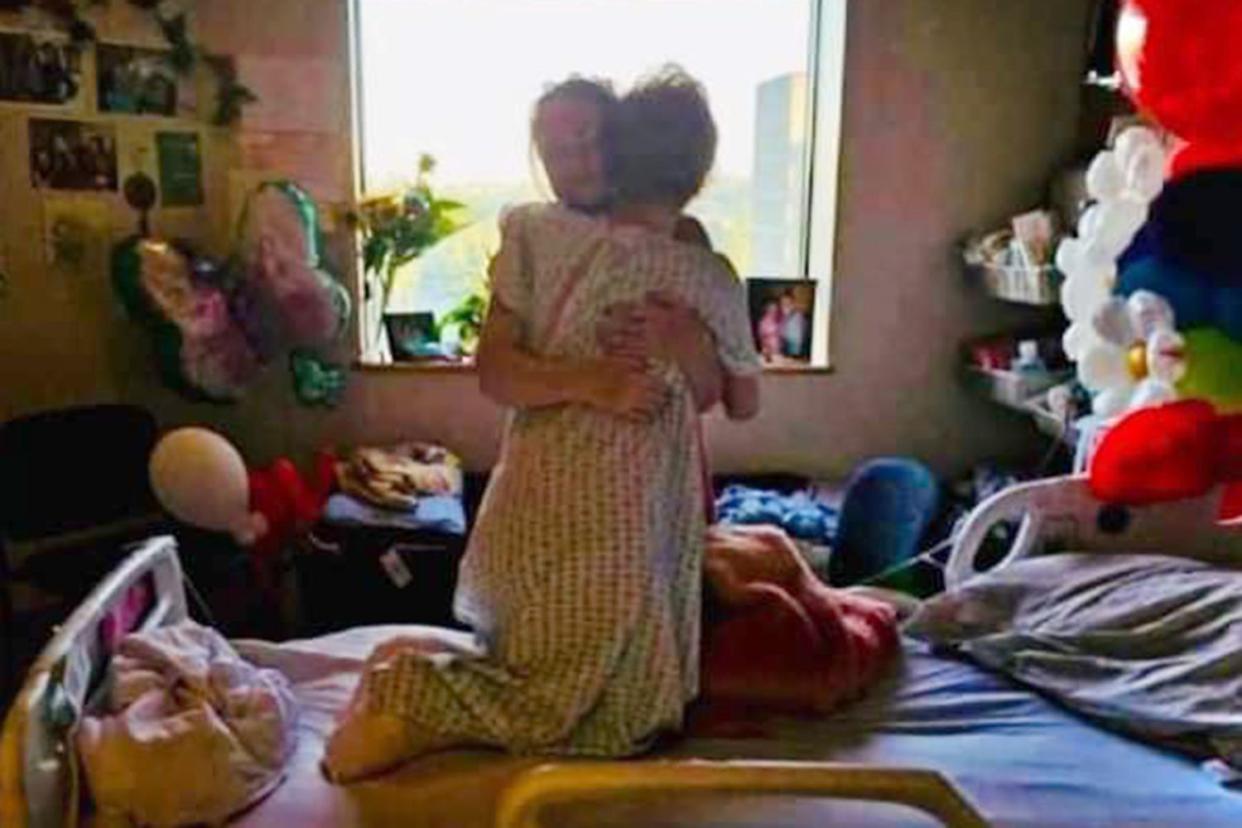 <p>Rob Compton</p> Mamie Laverock hugs her mom Nicole Compton.