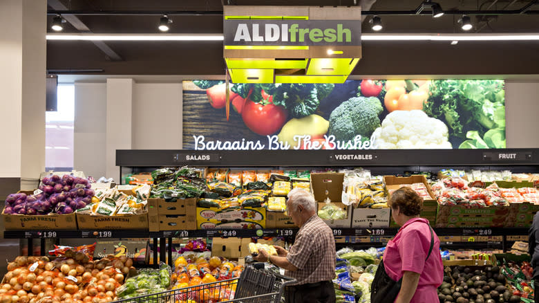 couple shopping for produce in aldi