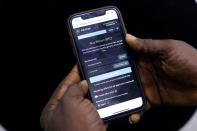 Abolaji Odunjo, a gadget vendor who trades with bitcoin, demonstrates a bitcoin application on his mobile phone after an interview with Reuters, at his store at the "Computer Village", in Lagos