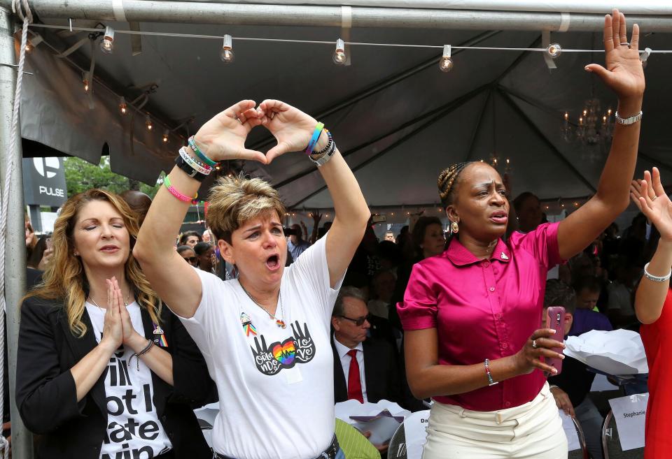 Barbara Poma, from left, owner of Pulse nightclub, and city commissioners Patty Sheehan and Regina Hill react during a public remembrance ceremony June 12, 2017, for shooting victims at Pulse nightclub in Orlando, Fla.